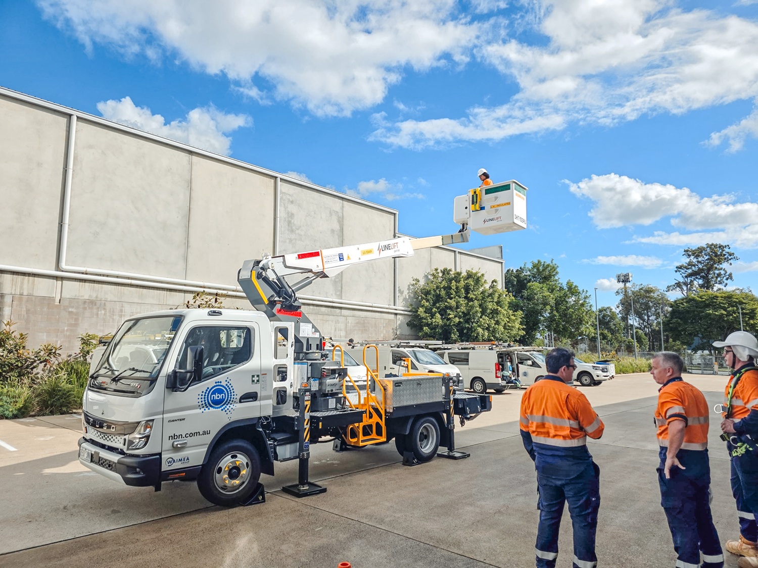 AU News Blog - The Ultimate Urban EWP Meet the Linelift® DHT105AU (1) A compact white EWP bucket truck with a boom and bucket mounted on the deck and outriggers on the sides, signwritten with Linelift® branding.