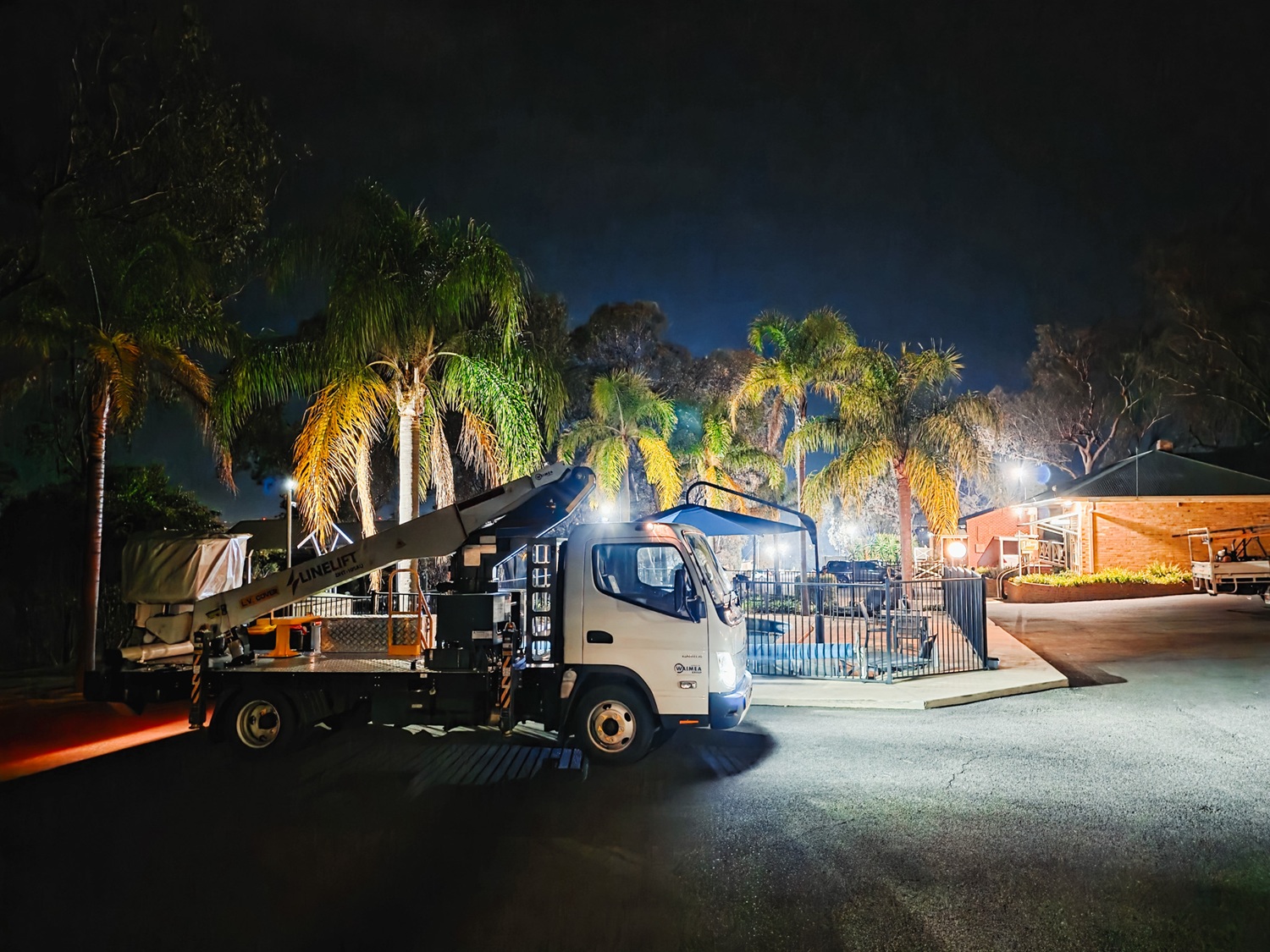 A compact white EWP bucket truck with a boom and bucket mounted on the deck and outriggers on the sides, signwritten with Linelift® branding.