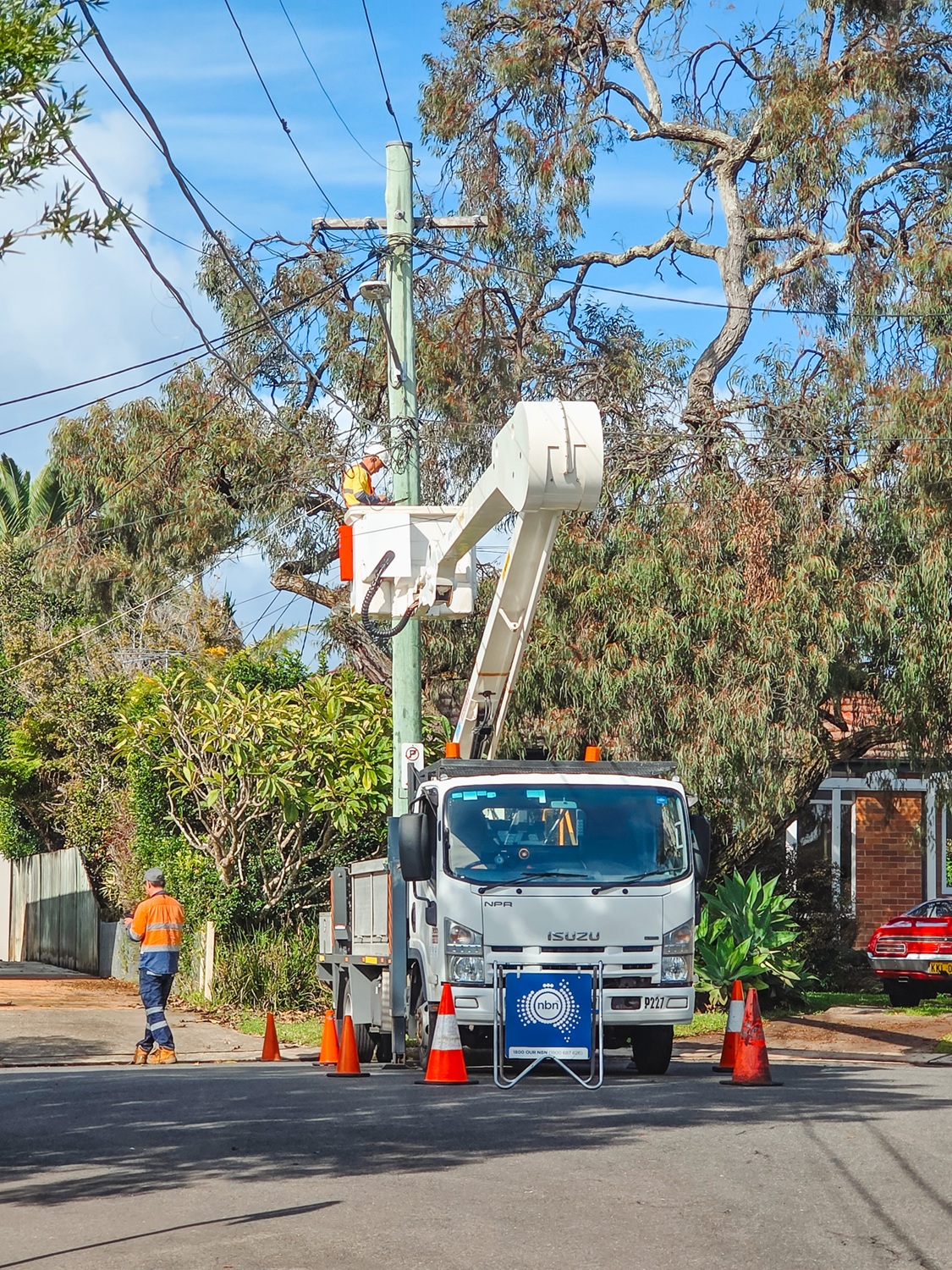 The Turnkey Truck Build Process Smarter EWP Solutions for Australian Businesses (4) Powerline workers look on as a white Linelift EWP bucket truck is demonstrated to them with the boom and bucket extended in their workyard.